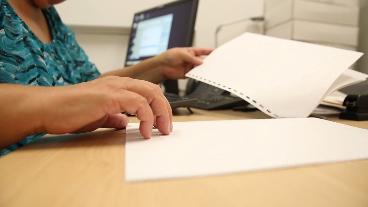 Image of a client reading braille