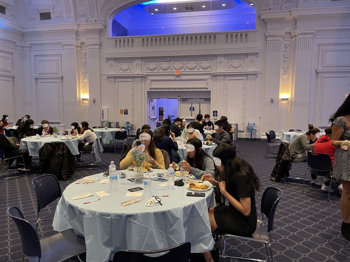 Image of case for sight students eating under blindfold at dinner in the dark