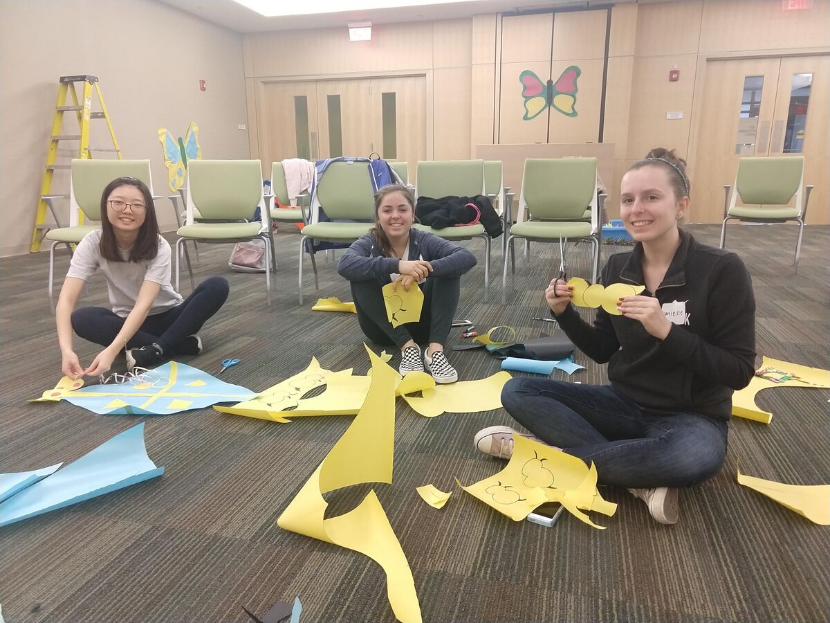 Image of three volunteers cutting paper