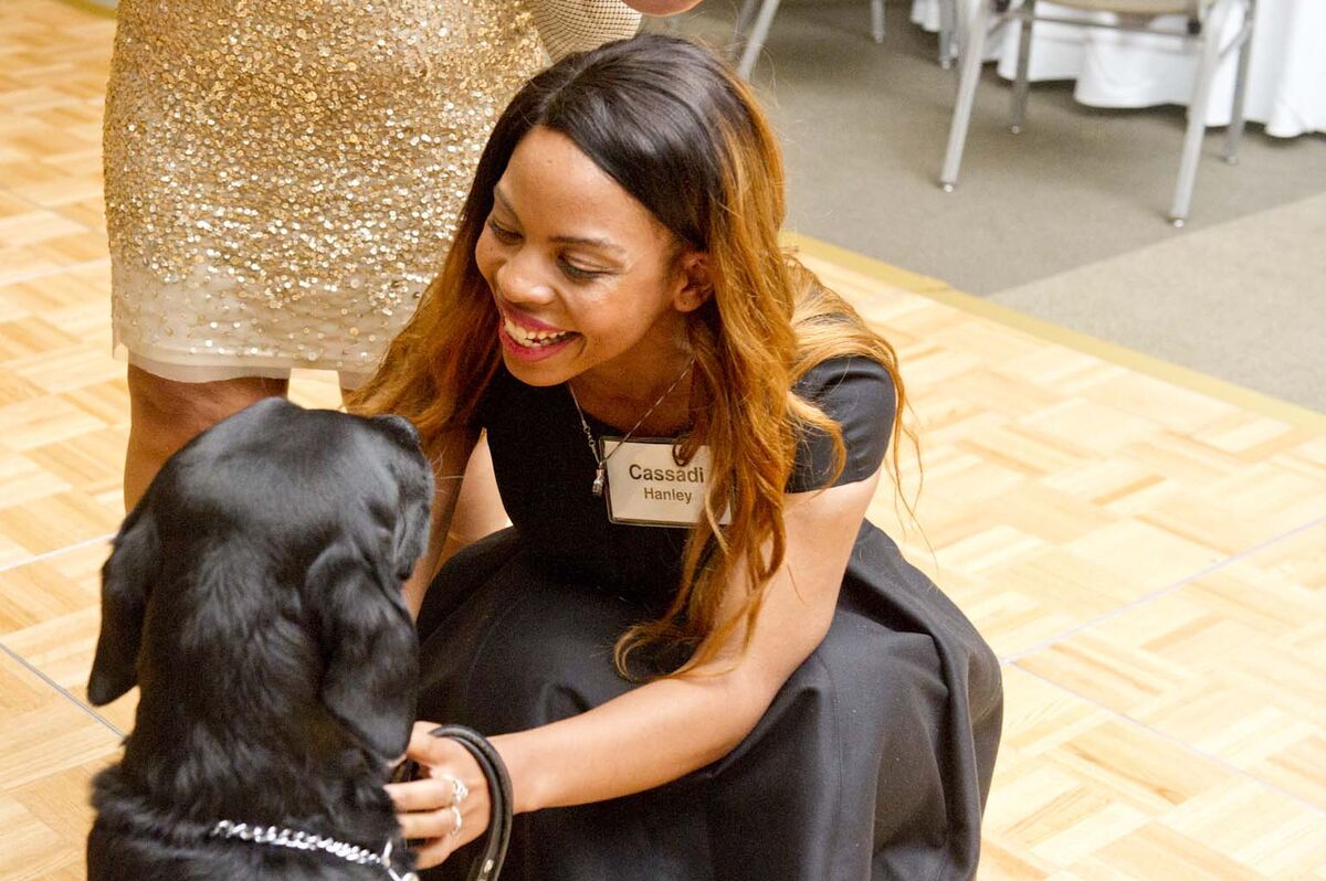 Image of a client smiling at her guide dog