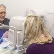 A woman looks into a machine at an eye doctor's office