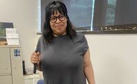 Chacity smiles and holds her white cane while wearing her ray ban meta glasses