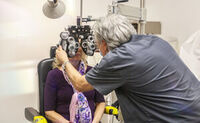 A woman gets her eyes checked by an eye doctor