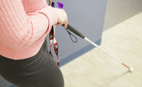 White cane user walking down a hallway