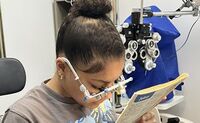 Aaliyah reads a newspaper with test lenses for bioptics.