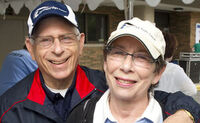 A photo of Mike and Fran Weissman smiling together with Cleveland Sight Center baseball caps on.