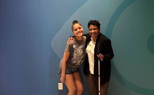 Aaliyah and CSC staff member standing next to each other and smiling for the camera in front of a blue wall with CSC's white logo on it