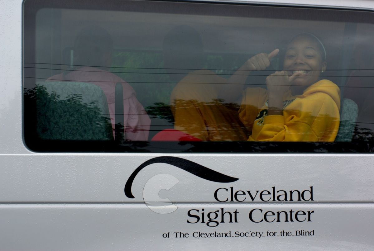 Camper giving thumbs up as the CSC vans get ready to head out for camp.