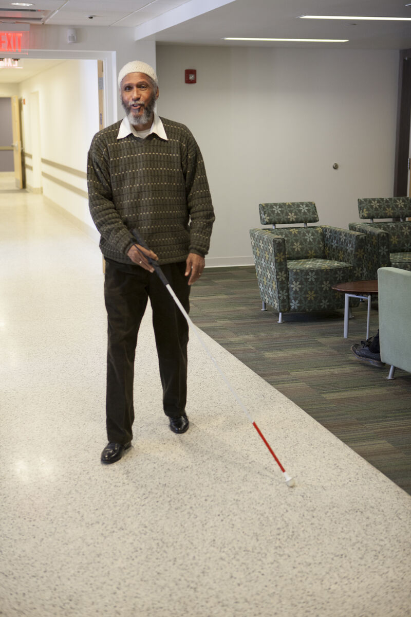 image of a person walking with a white cane