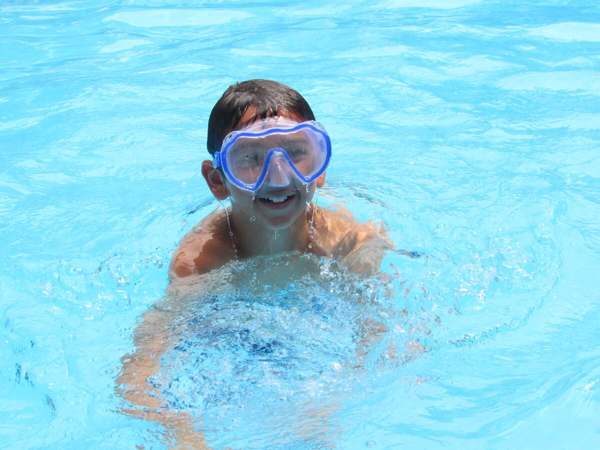 Camper swimming in the pool with goggles on