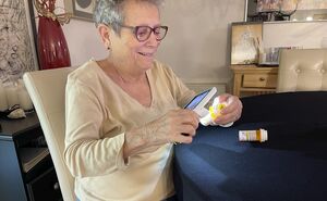 Mary Ellen uses an electric magnifier to read the print on her medication.