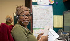A female call center agent smiling at her desk.