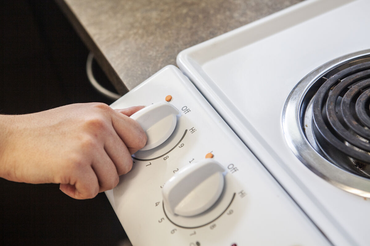 A stove top's heat control dials have orange bump dots to mark the heat level used most often. 