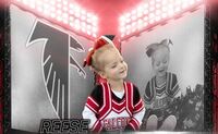 Reese Reese wears a cheerleading uniform that says Falcons across the chest. The uniform is black, red and white. Reese is smiling in the center of the photo, with a black and white photo of her in the background to the right. A gray falcon logo is behind her to the left.
