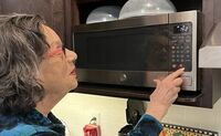 Ilene uses a bump dot to set the correct cooking time on her microwave.