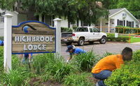 Volunteers working in the garden around the Highbrook Lodge sign.