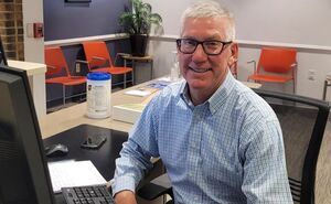 Dave smiles for a photo from his spot behind the front desk at Cleveland Sight Center's lobby.