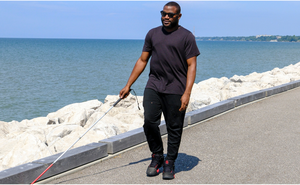 Kayshawn walks along a paved trail next to lake Erie.